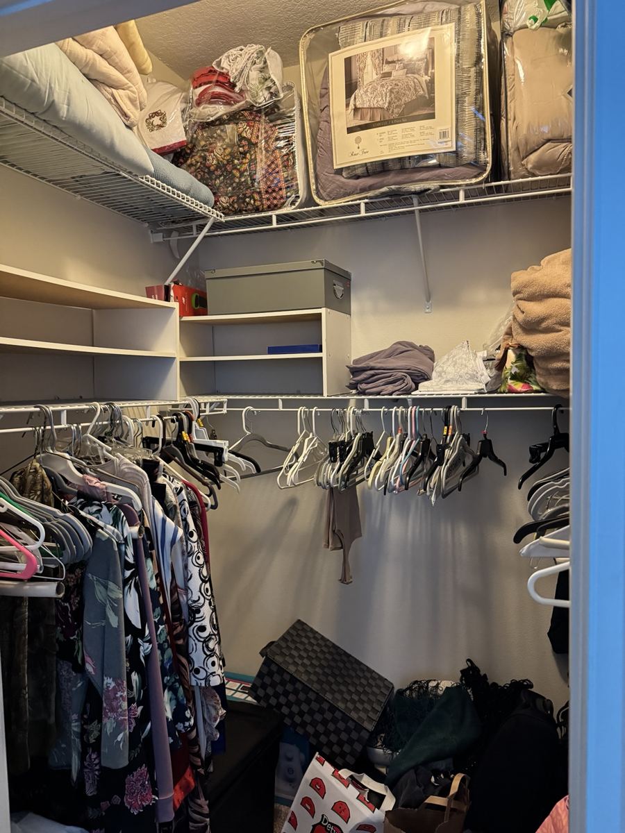 Walk-in closet clothing and stored belongings.